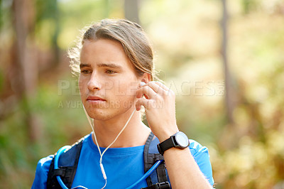 Buy stock photo Outdoor, athlete and man with earphones, nature and listening to music for fitness, thinking and park. Exercise, runner and person with tech for streaming, sound and radio for training in woods