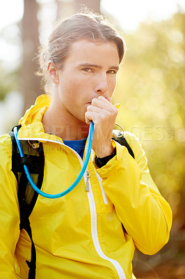 Buy stock photo Man, runner and drinking water in forest with bladder, tube and portrait in summer with break for fitness. Person, outdoor and hydration for wellness with trail running, exercise and rest in France