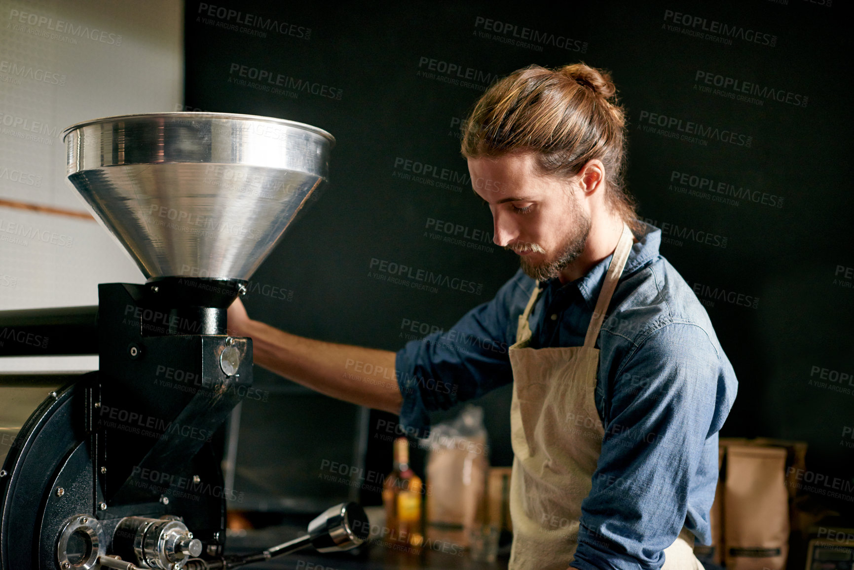 Buy stock photo Barista, equipment and ground coffee with man in factory for manufacturing of caffeine product. Business, cafe and preparation with person in kitchen or workshop for beverage, blend and brew