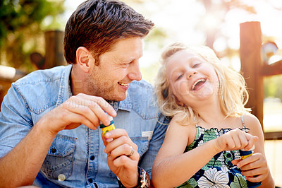 Buy stock photo Blowing bubbles, father and girl in park for bonding, together and outdoor for fun. Soap toy, child and man in garden with summer, holiday and daughter with care and play in nature for weekend