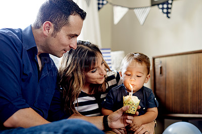 Buy stock photo Parents, child and cupcake for birthday in house for milestone with blowing candle for celebration. Dessert, sweets and mother with boy toddler, father and cake at party or event in family home