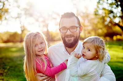 Buy stock photo Dad, portrait and hug with children in nature for summer fun, bonding or outdoor weekend together. Happy father, daughter or kids with smile or lens flare for holiday or family time on grass field