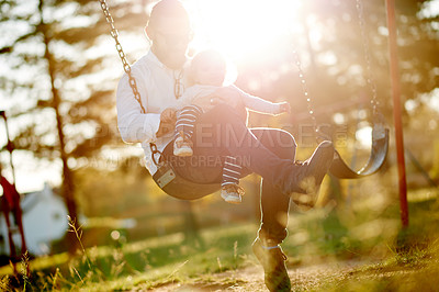 Buy stock photo Sunshine, swing and dad with kid in park for playing, fun and bonding on weekend in nature. Happy family, flare and father with girl on playground for vacation, holiday and adventure together outdoor