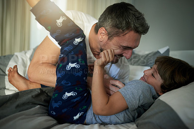 Buy stock photo Laughing, morning or tickle with father and son in bedroom of home together for bonding or fun. Happy, love or playful with boy child and single parent man on bed in apartment for weekend wake up