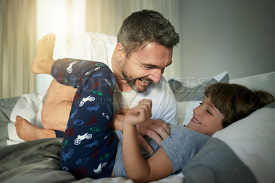 Buy stock photo Love, playful or tickle with father and son in bedroom of home together for bonding or fun. Happy, laughing or morning with boy child and single parent man on bed in apartment for weekend wake up