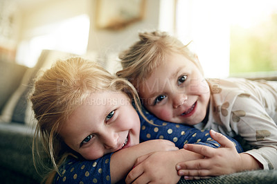 Buy stock photo Portrait, siblings and hug on sofa, lounge and girls with smile on break, care and together in home. Happy, sisters and relax on couch, love and affection for toddler, embrace or bonding on weekend