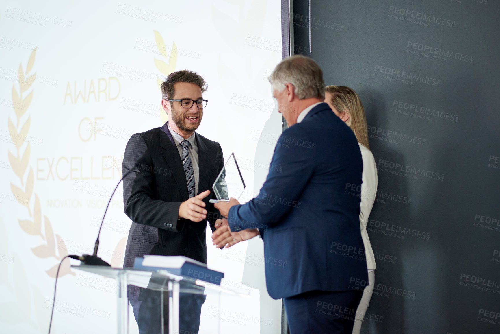 Buy stock photo Business people, award and meeting with trophy on podium for congratulations or achievement. Businessman, executive or reward with employee for promotion, winning or nomination for company excellence