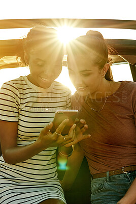 Buy stock photo Road trip, sunshine and women in car with phone for social media on holiday, vacation and adventure. Flare, online and happy people with smartphone for bonding on journey, destination and travel
