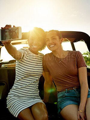 Buy stock photo Happy women, friends and car with selfie for road trip picture, photography or memory together. Female people, smile and capture moment with flare for outdoor travel, social media post or journey