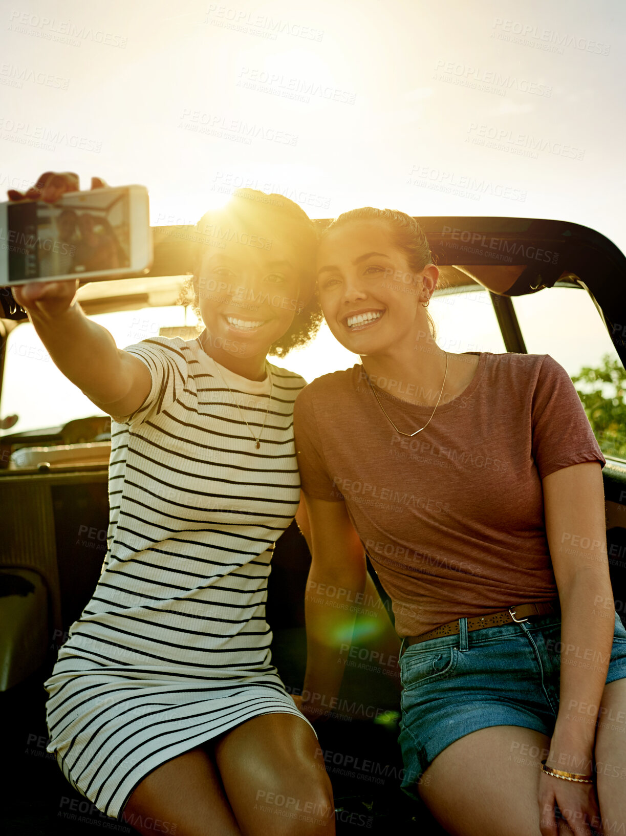 Buy stock photo Happy women, friends and car with selfie for road trip picture, photography or memory together. Female people, smile and capture moment with flare for outdoor travel, social media post or journey