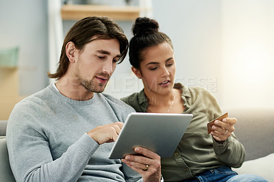 Buy stock photo Credit card, ecommerce and tablet with couple on sofa in living room of home together. App, checkout payment and online shopping with people in apartment for buying, finance decision or purchase