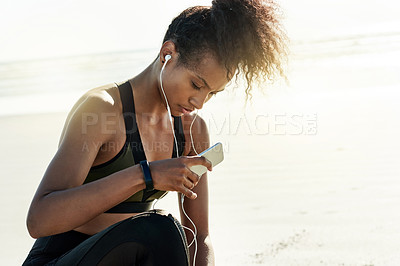 Buy stock photo Woman, smartphone and fitness at beach on break with music, reflection and rest with exercise by sea. Girl, earphones and runner with fatigue, audio or mobile app for subscription by ocean in Ecuador