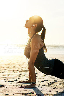 Buy stock photo Zen, yoga or woman at beach in cobra pose for posture, wellness or holistic health for calm soul. Music earphones, relax or person stretching spine for mindfulness audio, chakra balance or exercise