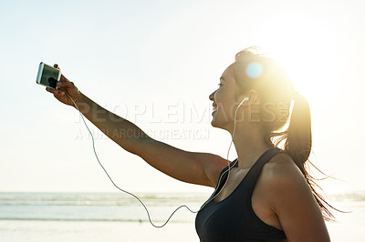 Buy stock photo Woman, smile or selfie on beach for fitness, social media update or live streaming with earphones. Sports influencer, happy or tech at sea for exercise photography, video call or follower interaction