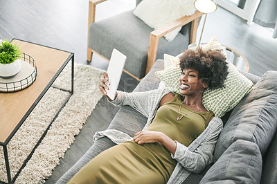 Buy stock photo Woman, happy and relax on sofa with tablet, streaming and above with movie subscription in home. African person, smile and tech on couch with application, social media or notification at apartment