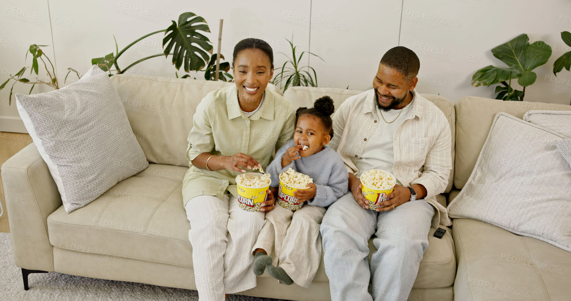 Buy stock photo Child, parents and watching tv with popcorn in home for entertainment or online streaming on sofa. Mom, dad or kid eating snacks with daughter for movie, subscription or network service in high angle
