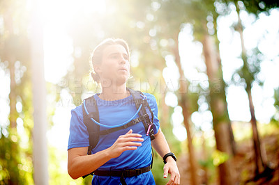 Buy stock photo Running, active and man in nature, outdoor and training in woods for fitness, healthy and serious. Cardio, athlete and person with backpack for jog, sportswear and exercise routine for performance