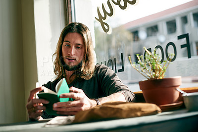 Buy stock photo Man, tourist and reading with notebook in cafe for travel destination, checklist or daily schedule. Male person, traveler or memo with to do list for reminder, tasks or planning trip in restaurant