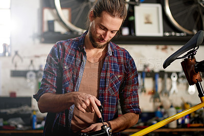 Buy stock photo Shop, mechanic and man with tool for bicycle, restoration or maintenance with screwdriver in garage. Inspection, technician and person with equipment for bike, fixing or service in small business