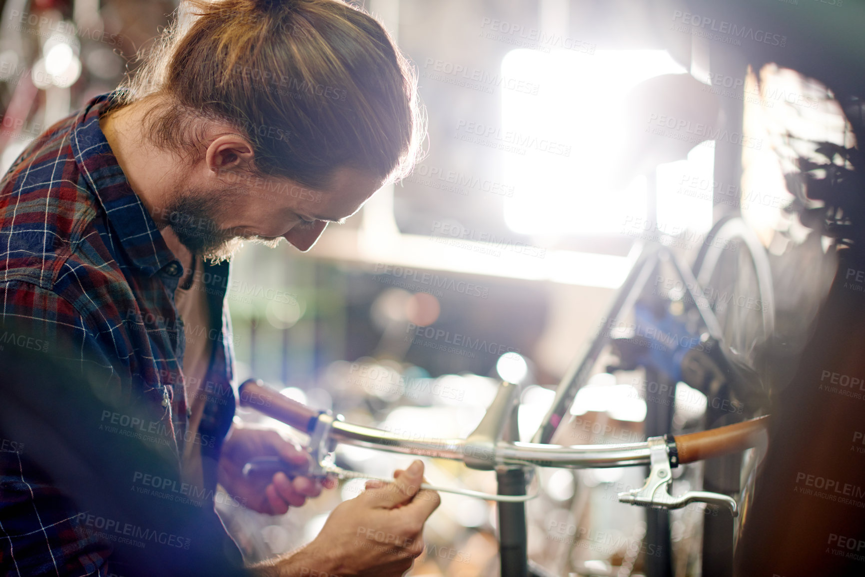 Buy stock photo Industry, repairs and man with fixing bicycle in garage for maintenance on wheels, chain or frame. Small business, service and male mechanic with tightening mechanical part on bike at workshop.