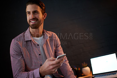 Buy stock photo Night, designer and phone in office with thinking, project feedback and laptop screen for creativity. Creative man, smile and tech in agency for late networking, social media campaign and planning