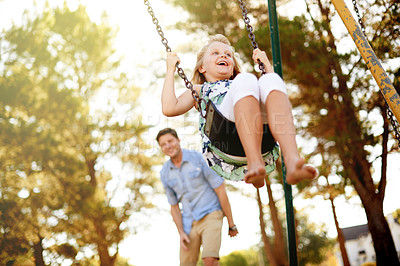 Buy stock photo Swinging, father and girl with smile, outdoor and bonding together with happiness, game and laughing. Relax, family and dad with daughter, weekend break and parent in playground, nature and excited