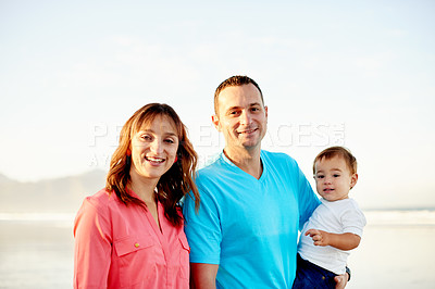 Buy stock photo Happy family, portrait and beach with baby for holiday, weekend getaway or outdoor bonding. Dad, mom and child with smile on ocean coast or sea for summer vacation, free time or childhood in nature