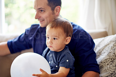 Buy stock photo Balloon, birthday or celebration with dad and son on sofa in living room of home for milestone. Development, growth or party with boy child and single parent man in apartment for bonding as family