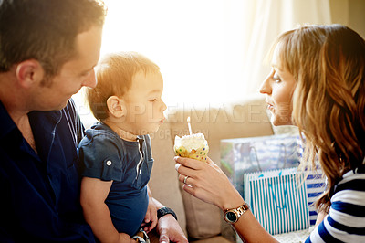 Buy stock photo Parents, kid and cupcake for birthday with blowing candles in home for milestone or celebration. Dessert, sweets and mother with boy toddler, father and cake at party or event in family house
