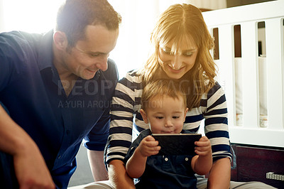 Buy stock photo Happy family, toddler and playing with phone for entertainment or early childhood development in home. Dad, mom and boy kid with mobile smartphone for bonding, streaming app or engagement in nursery
