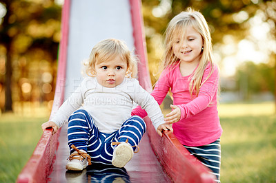 Buy stock photo Playground, happy and children on slide in park for outdoor adventure, playing together and having fun. Family, summer and siblings in nature for bonding, connection and relationship on weekend