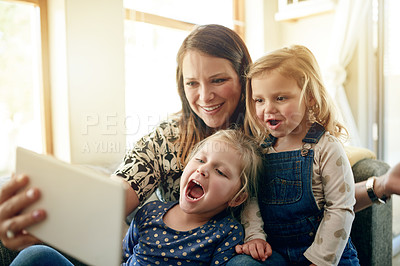 Buy stock photo Mother, children and tablet on sofa with smile, love and together for video, cartoons and relax in home. Woman, girls and digital tech for social media, games or movies in living room in family house