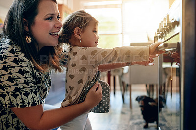 Buy stock photo Oven, baking and help with mother and daughter in kitchen for cupcake, cooking and learning. Support, food and teaching with woman and child in family home for dessert, bonding and love together