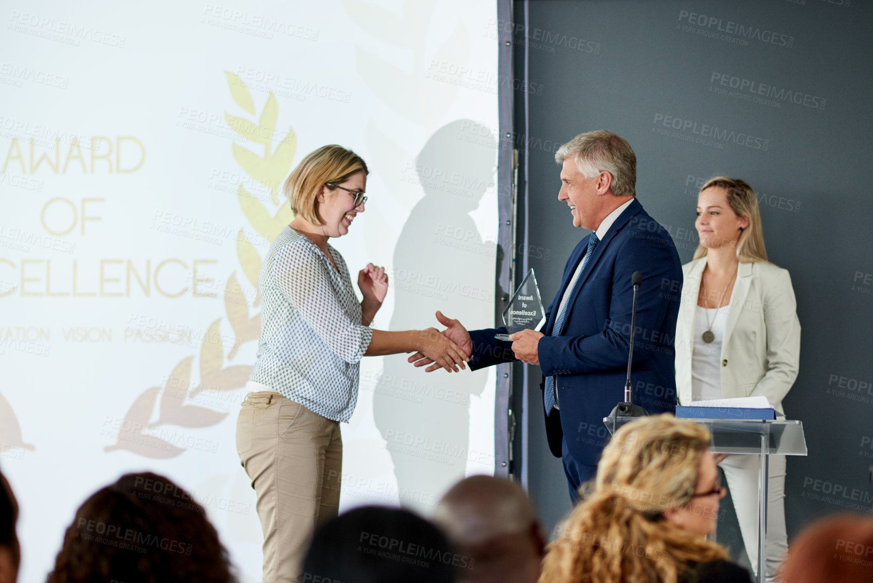 Buy stock photo Business people, award and handshake with trophy on podium for congratulations or achievement. Businessman, executive or shaking hands with rewards for promotion, winning or nomination for excellence