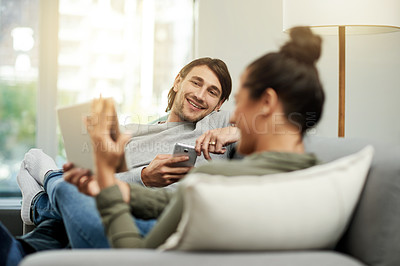Buy stock photo Conversation, relax and tablet with couple on sofa in living room of home together for break. App, phone and sharing with happy people talking in apartment for connectivity, browsing or social media