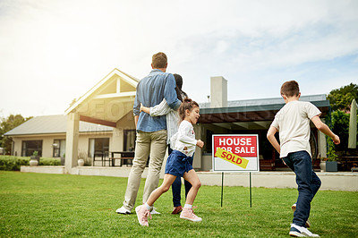 Buy stock photo Real estate, hug and family with new home, sold sign and milestone for homeowner with property and yard. Outdoor, mortgage and people with investment of house, playing and parents with children