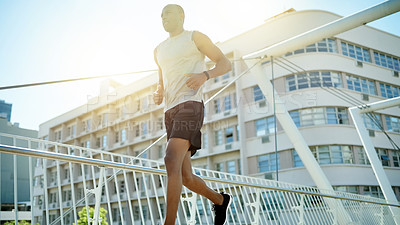 Buy stock photo Running, fitness and sports with black man in city for cardio challenge, marathon practice and athlete. Workout, training and wellness with low angle of person on bridge for race and endurance