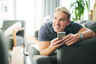 Buy stock photo Happy man, phone and laying on sofa in home, relax and thinking with texting for web chat in lounge. Mature person, smartphone and search on mobile app with reflection, smile or social media at house
