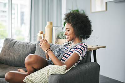 Buy stock photo Break, phone and smile with woman on sofa in living room of home for weekend post or update. App, relax and text typing message with happy African person in apartment for download or mobile chat
