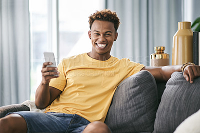 Buy stock photo African man, happy and phone on sofa, home and relax with notification for online dating in lounge. Person, smartphone and smile with mobile app, contact or chat on social network at house in Kenya