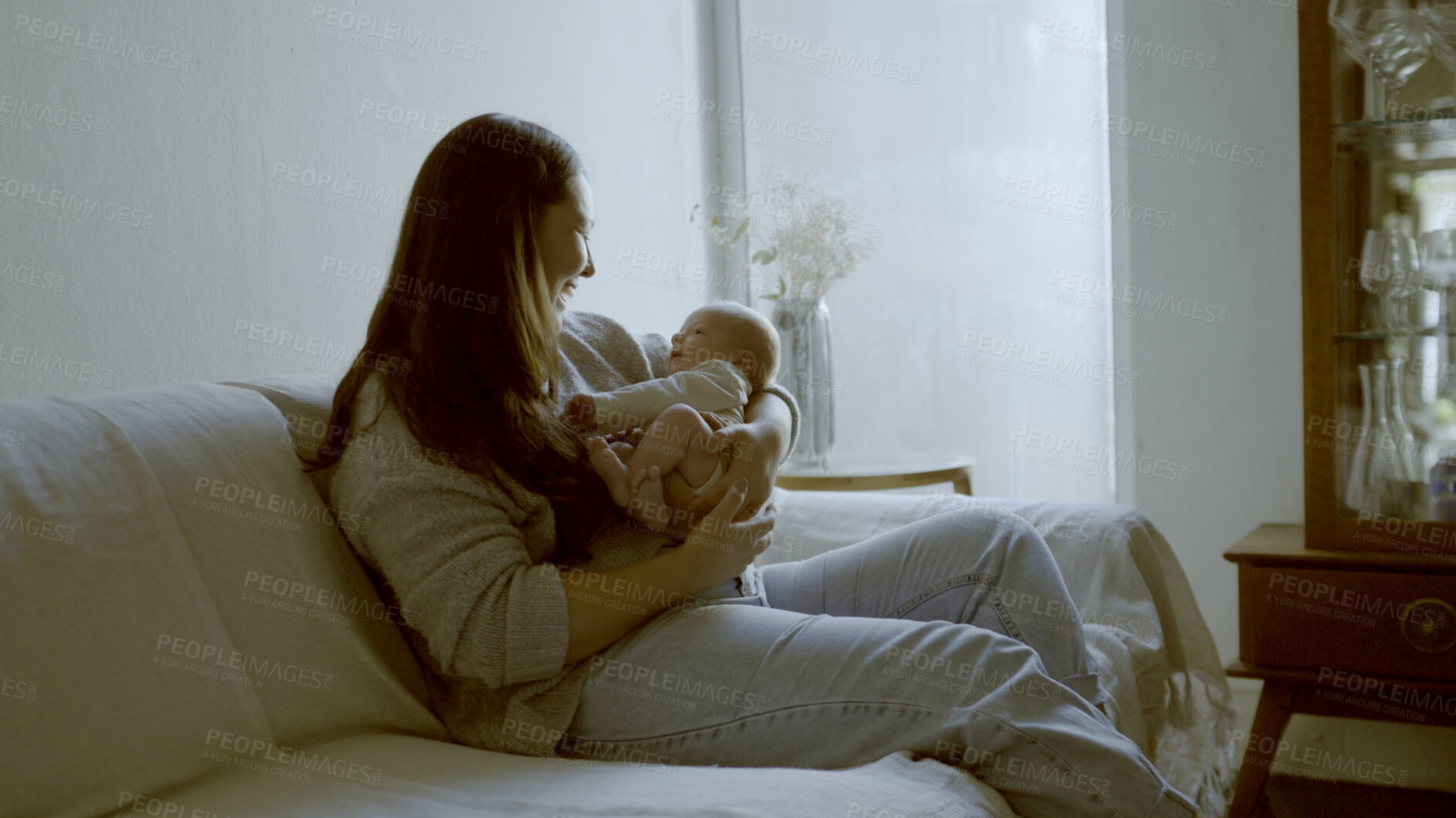 Buy stock photo Smile, love and mom with her newborn on a sofa for relaxing, bonding and resting in living room. Happy, care and young mother holding her infant, baby or child with happiness in lounge of family home