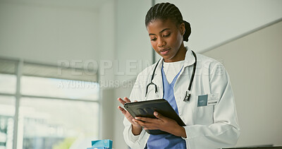 Buy stock photo Female doctor, typing and tablet for consultation in medical office, clinic or hospital. Black woman, face and looking at screen for message, email or app with online, diagnosis or result for review