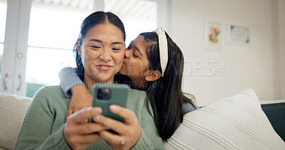 Buy stock photo Phone, mother and child on sofa with kiss, hug and love connection for social media browsing. Asian family, happy mom and kid in home with affection, healthy relationship or online reels with bonding