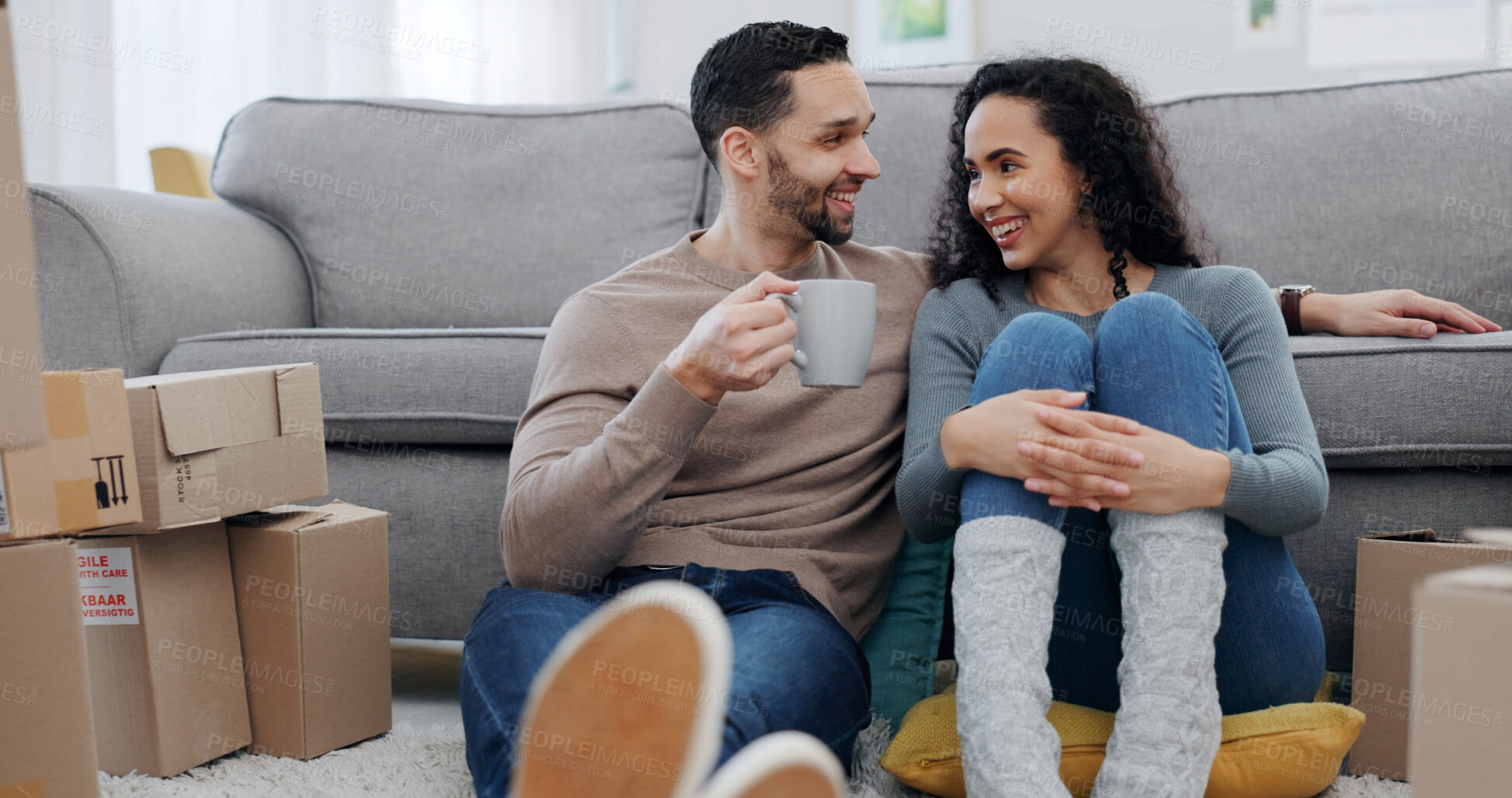 Buy stock photo Sofa, boxes and happy couple relaxing in new home for relocation, real estate or ownership together. Man, woman and chilling with drink or coffee for relationship, mortgage loan or property start