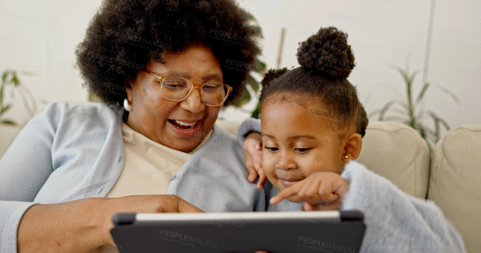 Buy stock photo Grandma, online and child with tablet in home, laughing and watching cartoons with subscription. Family, bonding and senior black woman with daughter, happy and streaming movie with tech in house