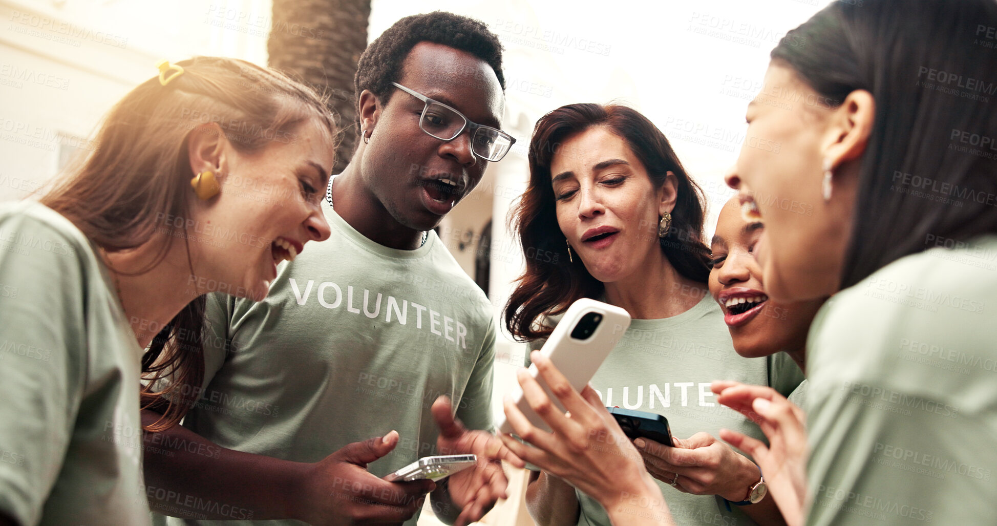 Buy stock photo Excited, people and phone outdoor for volunteering, good news and success of outreach target. Surprise, team or laugh with mobile for celebration, winning award and positive feedback on charity event