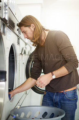 Buy stock photo Man, washing and basket with clothing in laundromat for commercial self service, customer or cleaning at shop. Male person, loading or drying garments with automatic machine for personal hygiene
