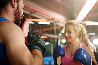 Buy stock photo Boxer, teaching or woman with coach for fighting exercise, boxing punch or self defense gym. Pads, learn or client in sports practice for training technique or fitness workout with personal trainer