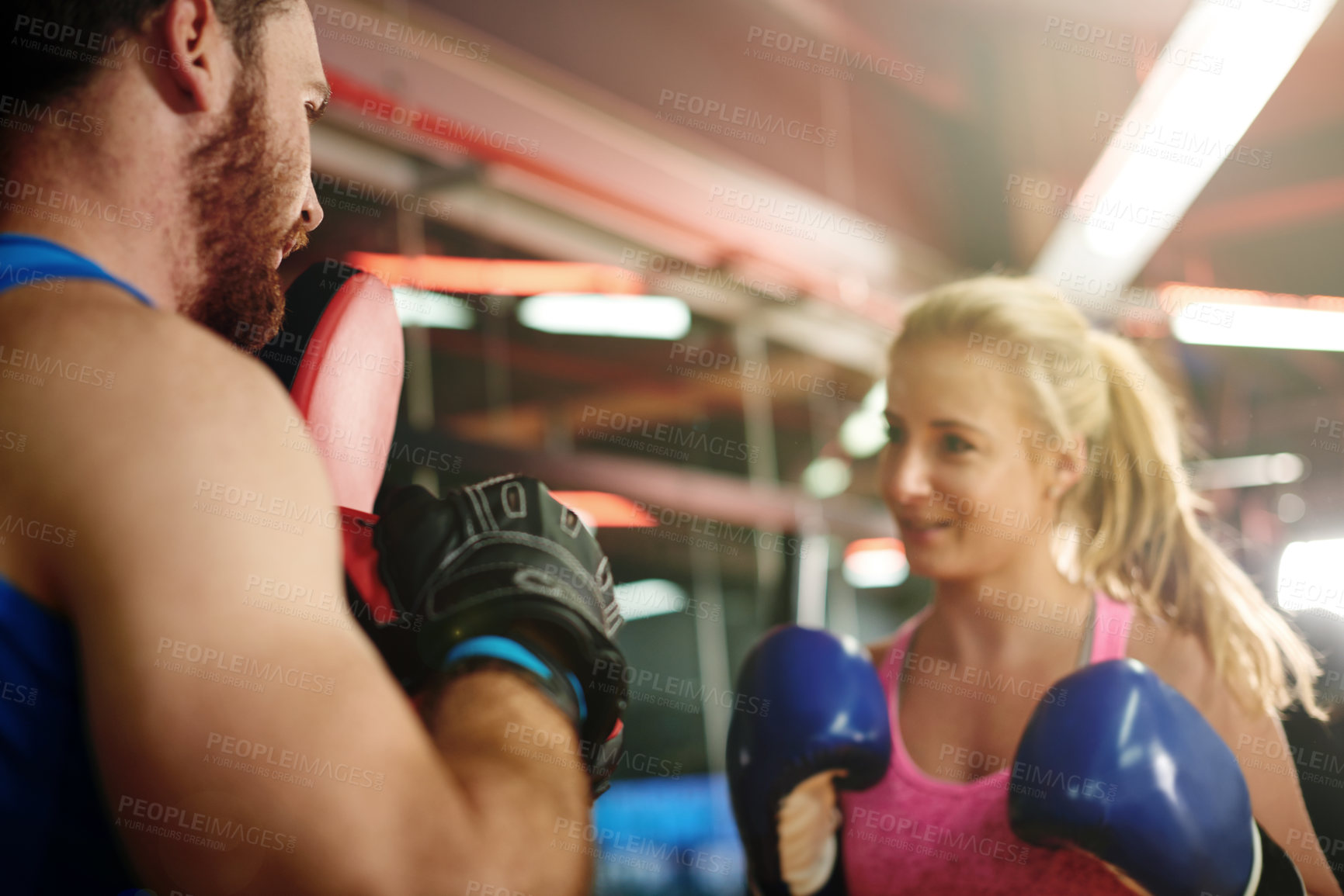Buy stock photo Boxer, teaching or woman with coach for fighting exercise, boxing punch or self defense gym. Pads, learn or client in sports practice for training technique or fitness workout with personal trainer