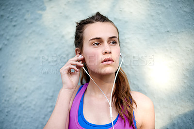 Buy stock photo Girl, fitness or listening to music with earphones on wall background for audio streaming or podcast. Active, female person or teenager with sound or break for online playlist, entertainment or songs